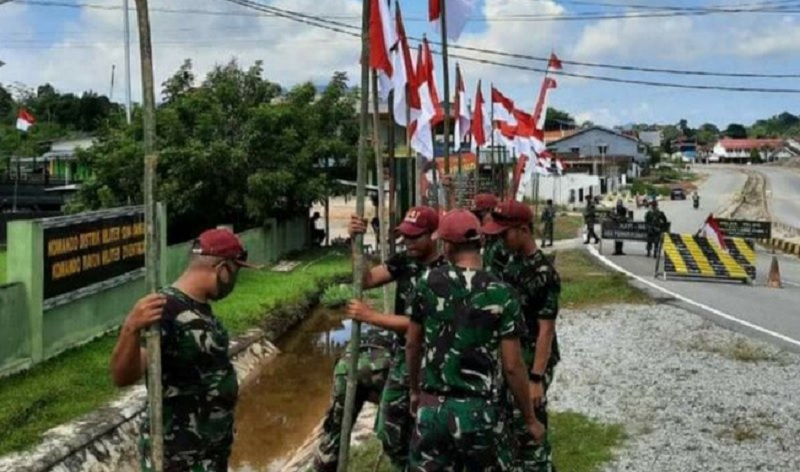 Jelang Peringatan HUT RI Ke-75, Satgas Pamtas Memasang Bendera Merah Putih di Wilayah Perbatasan Dengan Malaysia