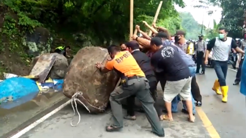 Sejumlah Petugas BPBD Sumbar Dibantu Warga dan Relawan Mengevakuasi Batu Besar di Tengah Jalan Padang-Painan