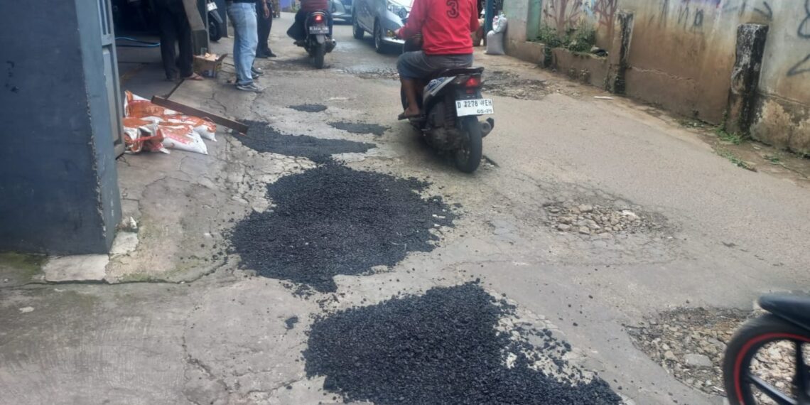 Jalan Ciguruwik Cinunuk Dibiarkan  Berlubang, Opang dan Warga pun Menambalnya